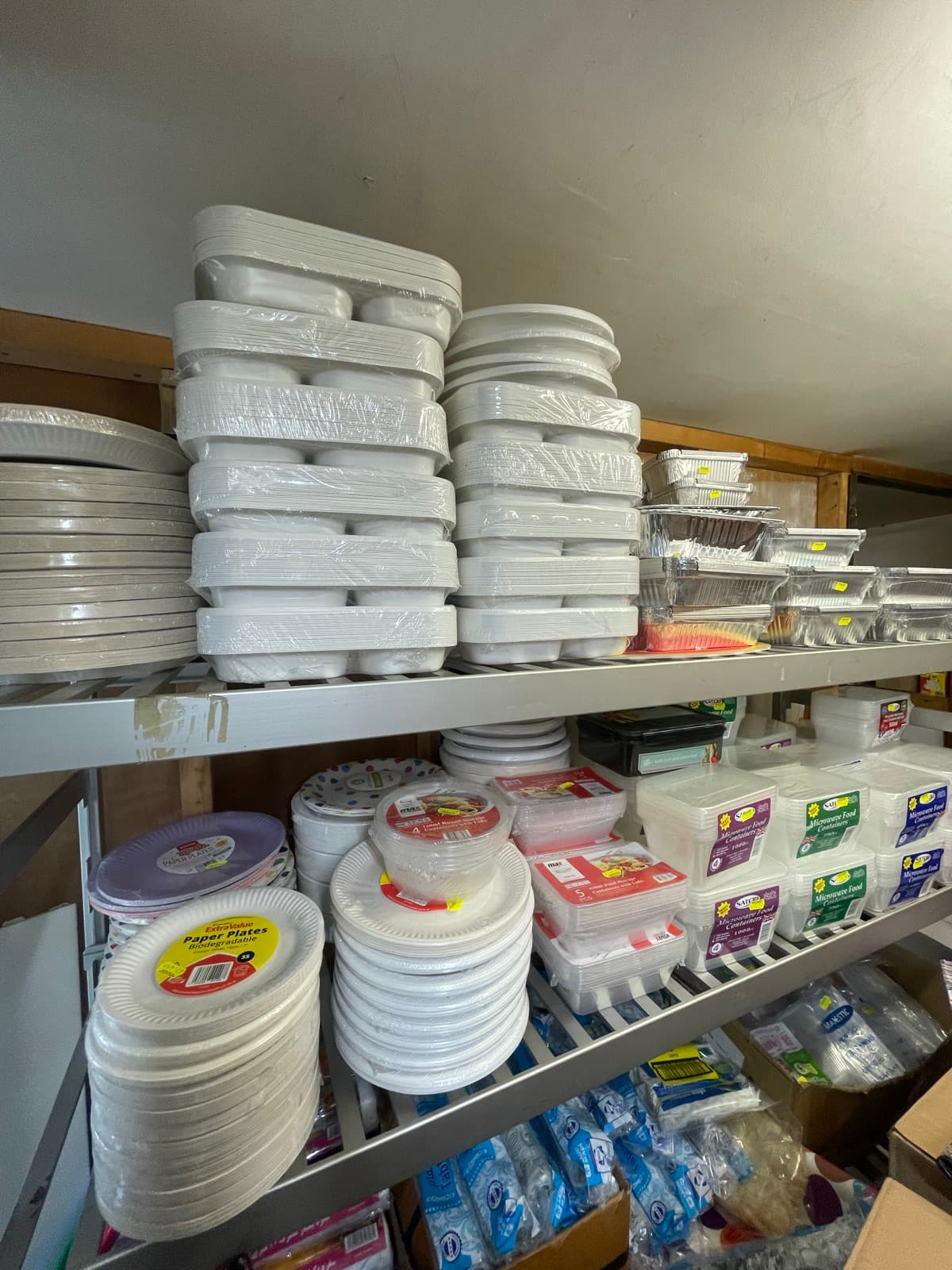 Shelves of disposable foil trays and plastic tableware