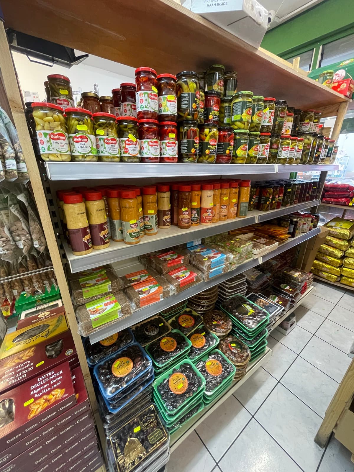 Rows of jarred olives and pickles on the deli shelves